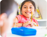Leaven Kids chid smiling with pencil in hand
